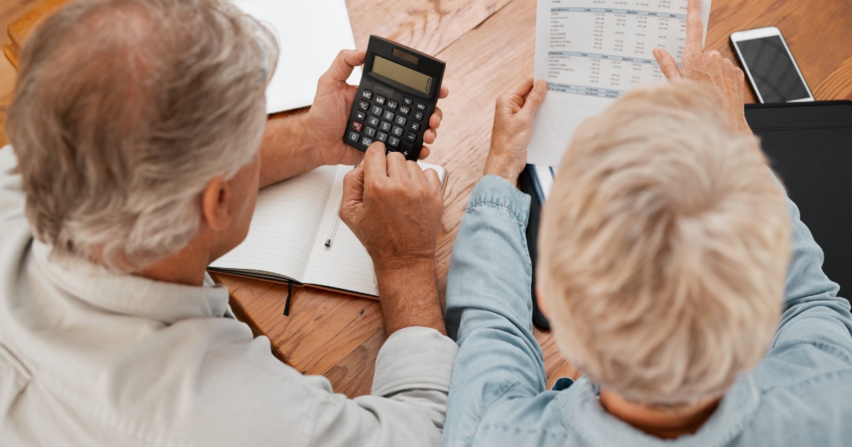 Couple de retraités discutant et calculant leurs impôts locaux.