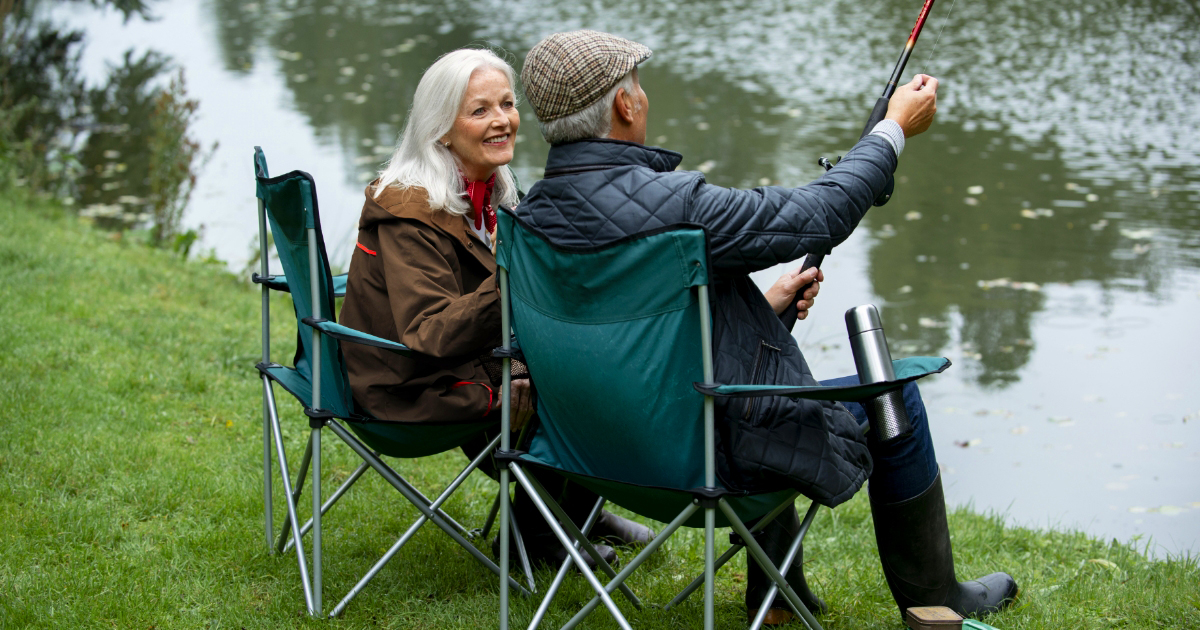 Un couple senior au bord d'un lac profitant de leur escapade campings.com 